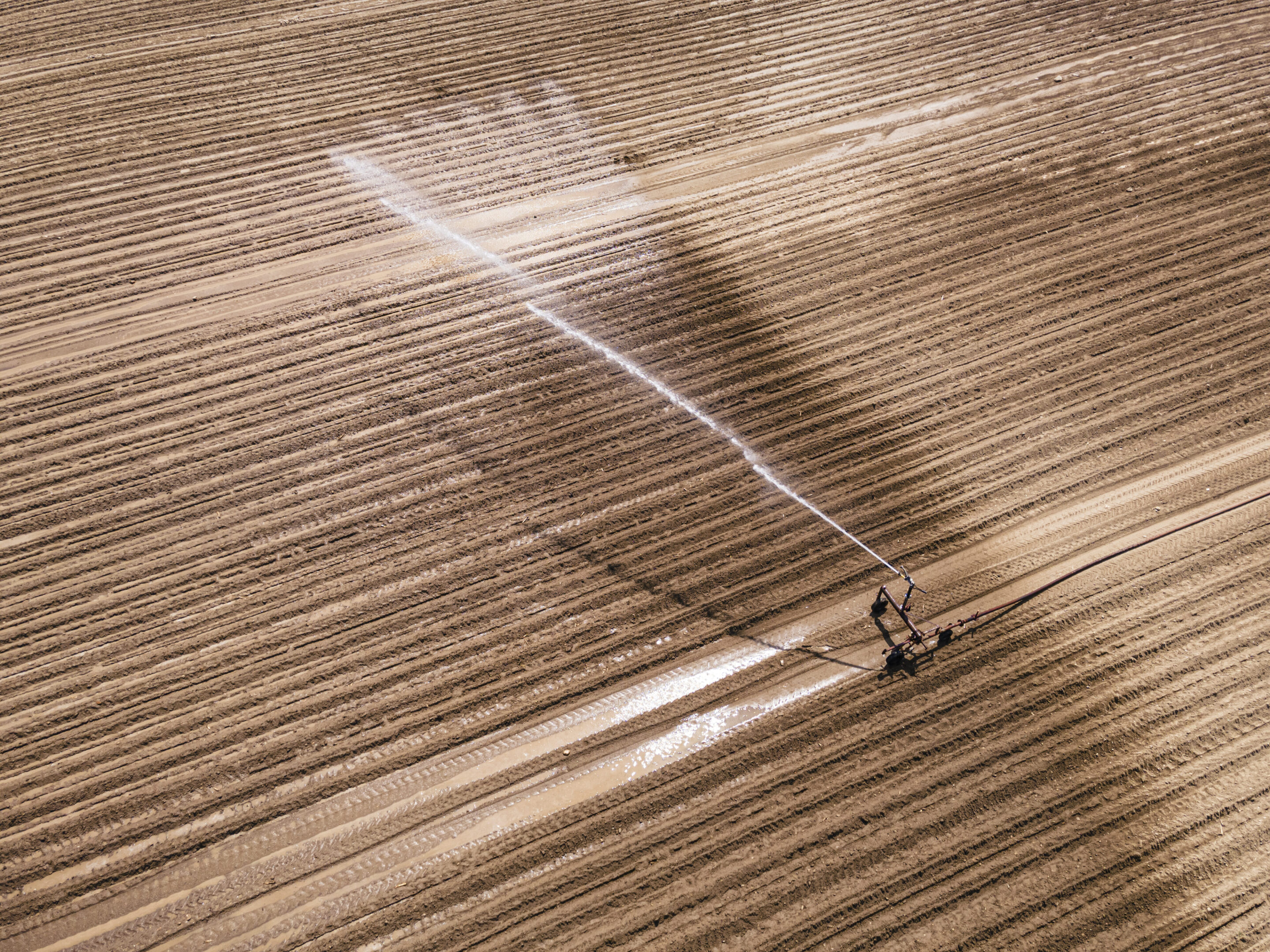 Irrigation system watering a large dry field.